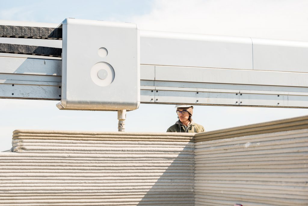 3D printer printing concrete home to solve homelessness