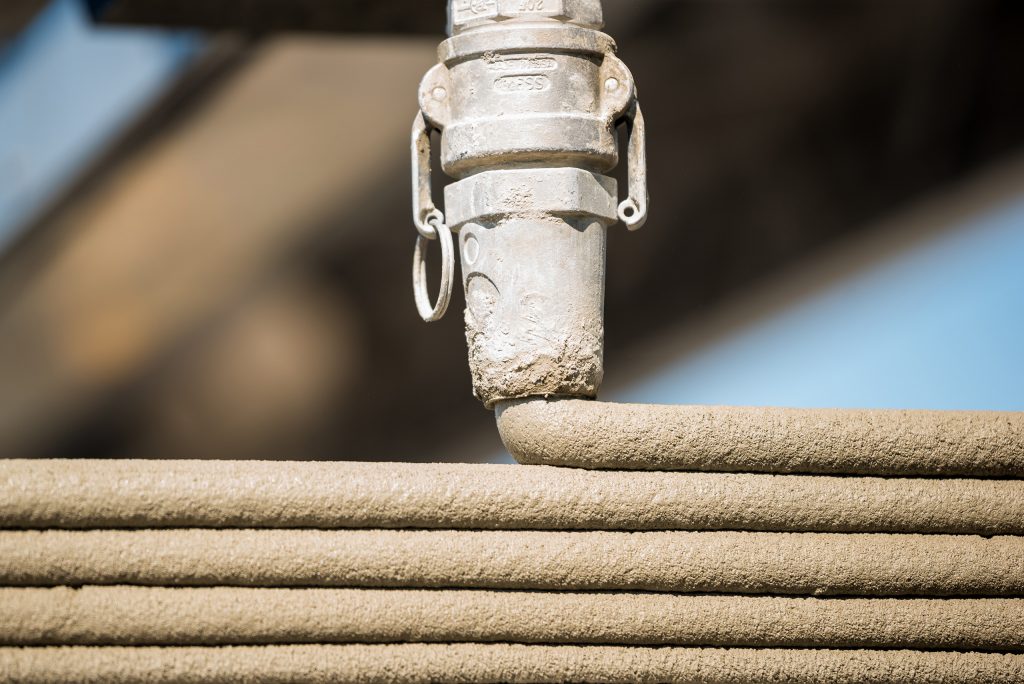 3D printer printing concrete home to solve homelessness