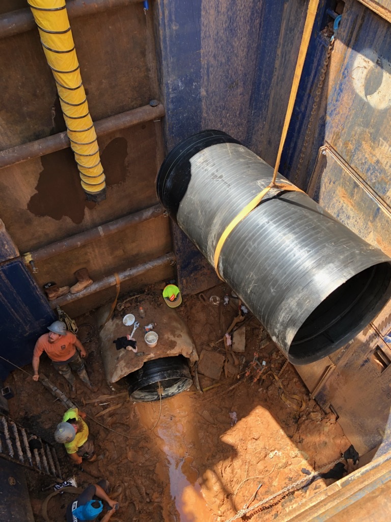 plastic pipe being lowered into hole
