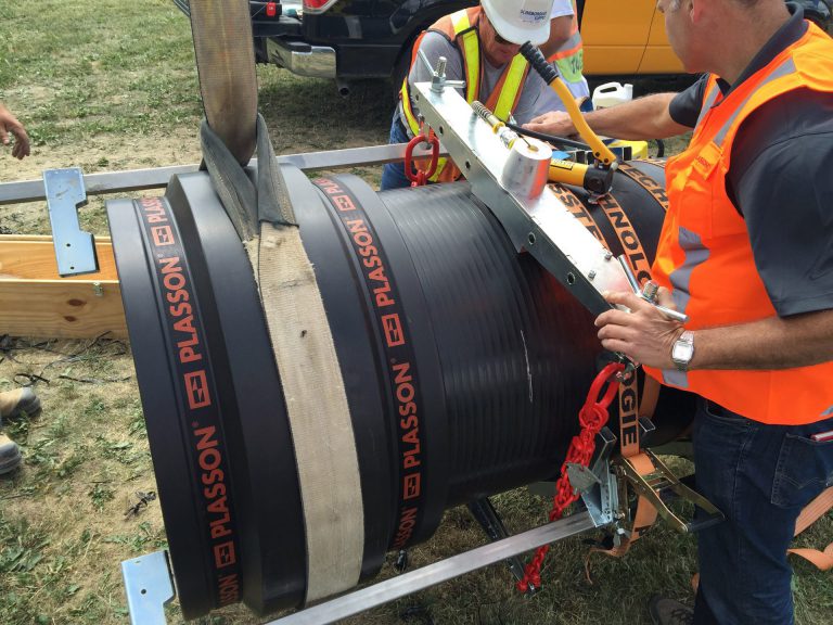 construction worker measuring Plasson polythylene pipe