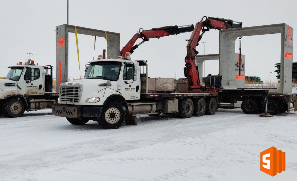 transport trucks with concrete culverts on bed