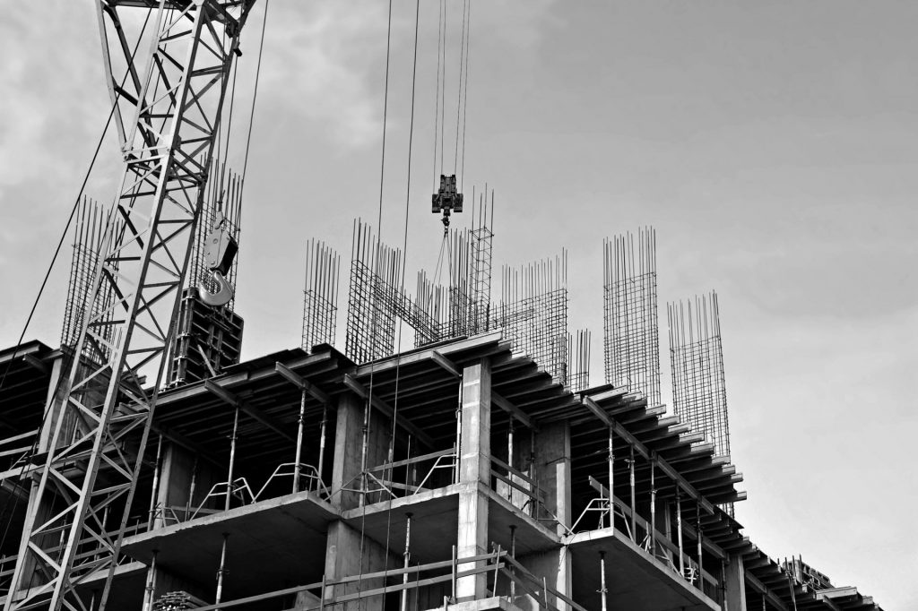 apartment building under construction with cranes and rebar